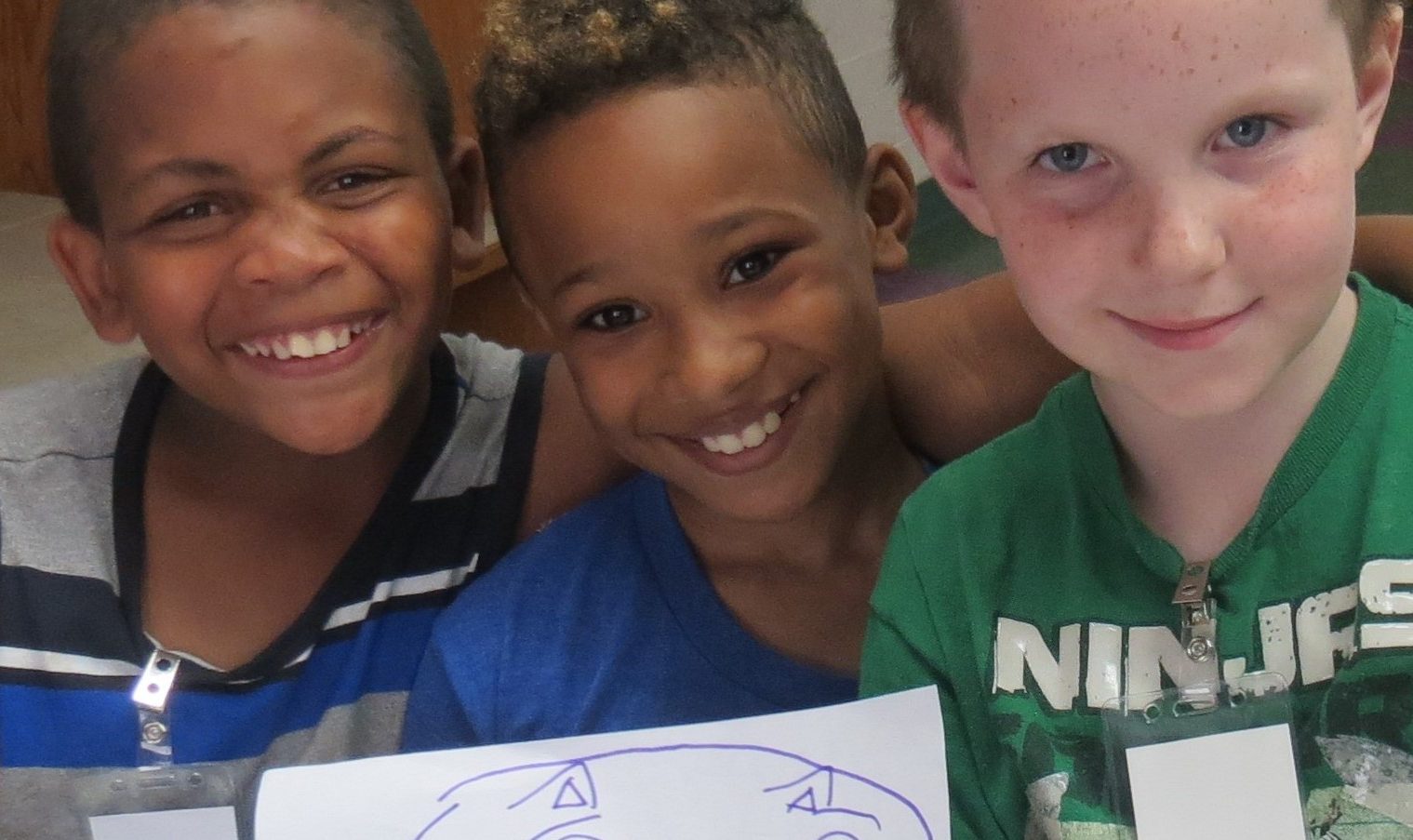 smiling children holding a drawing