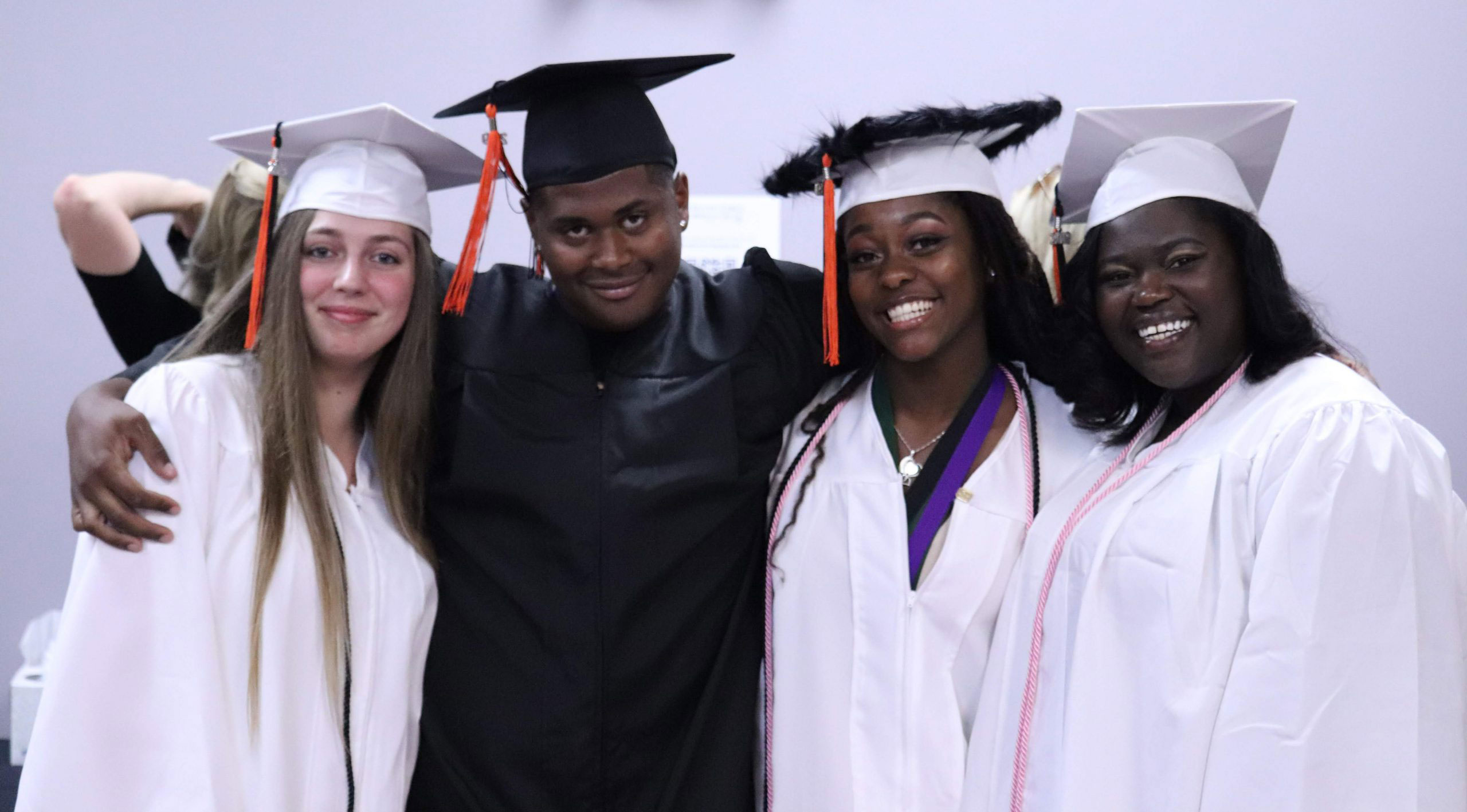 graduates with their arms around each other